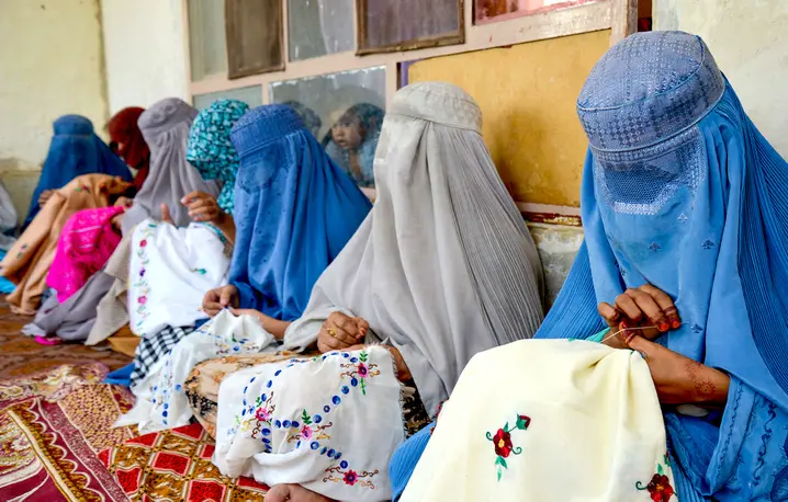 Afgańskie kobiety ubrane w burki podczas kursu haftowania. Kandahar, 4 września 2024 r. // Fot. Anaullah Seiam / AFP East News